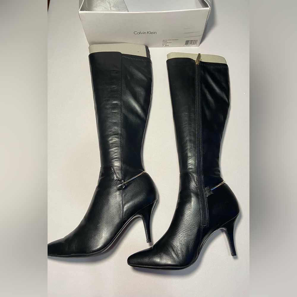 Tall boots, small heels, pointy front. It has a gold detail at heel base